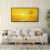 Minimalist yellow sun landscape wall art in black frame above modern white sofa with geometric wallpaper