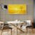 Minimalist yellow landscape wall art framed above wooden dining table in modern dining room