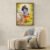 Little Krishna with cows wall art framed above modern armchair, devotional Krishna artwork for living room decor.