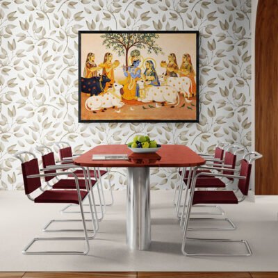 Radha Krishna devotional wall art in black frame displayed above a modern dining table with patterned wallpaper background.