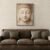 Minimal Zen Buddha face wall art displayed above leather sofa in modern living room.