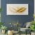 White and gold leaf canvas wall art displayed on dark blue wall with modern gold decor accents