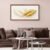 White and gold botanical canvas print displayed above modern neutral sofa